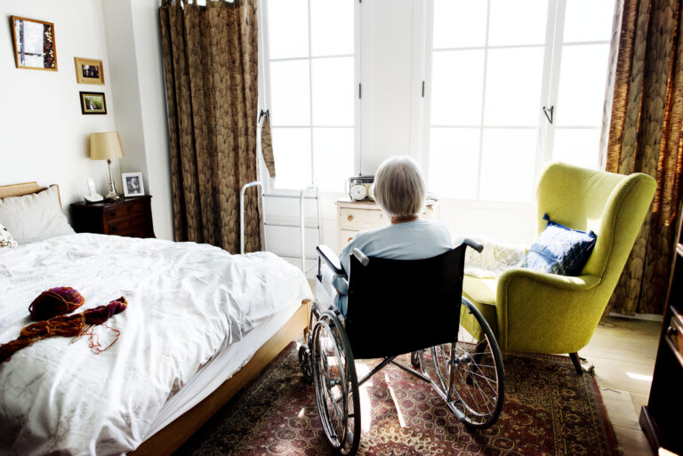 Senior woman sitting in wheelchair alone